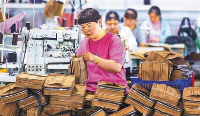 阜平縣顧家臺村九歌皮具有限公司,村民在加工箱包。當地生產的箱包通過線上線下俏銷全國各地。